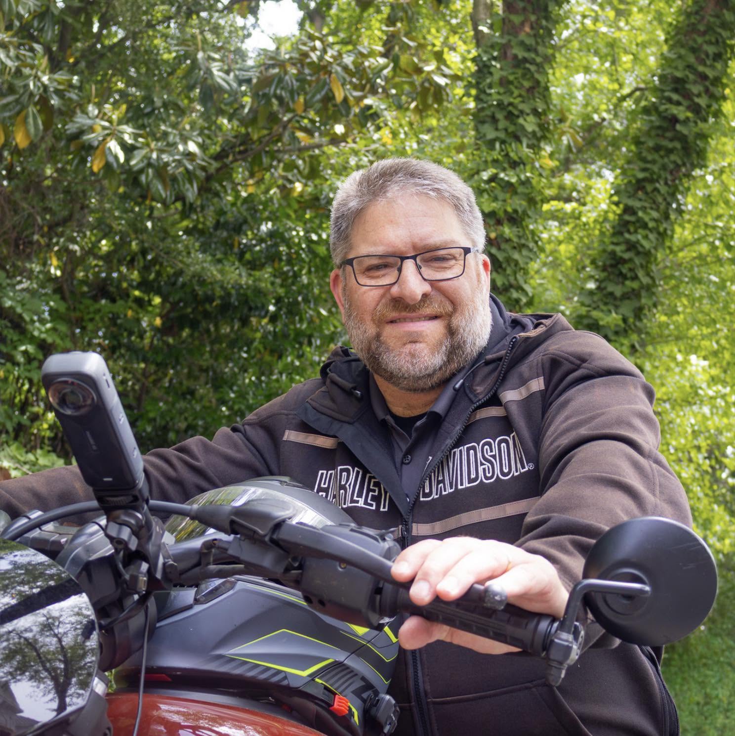 Mark Tahsler smiling while sitting on his motorcycle